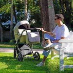 a man sitting on a bench next to a baby stroller